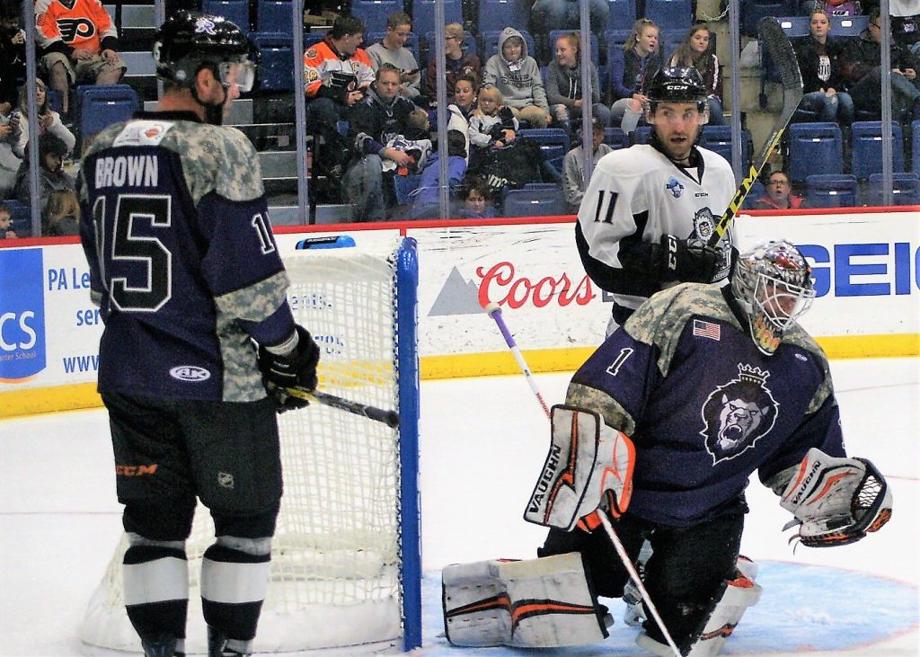 Reading’s G John Muse gloves the puck as Royals Tyler Brown and Jacksonville’s Cameron Critchlow have a staredown.
